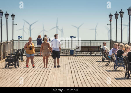 Skegness, UK. 2nd July 2018. Tourists enjoying the hot weather on Skegness Pier and viewing the offshore wind farms through the heat haze on the East Coast towards the usually cold North Sea. Credit: Steven Booth/Alamy Live News. - Stock Photo