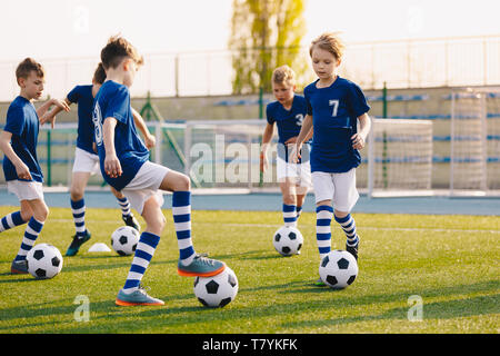 Young Boys of Sports Club on Soccer Football Training. Kids Improving Soccer Skills on Natural Turf Grass Pitch. Football Practice Session for Childre - Stock Photo